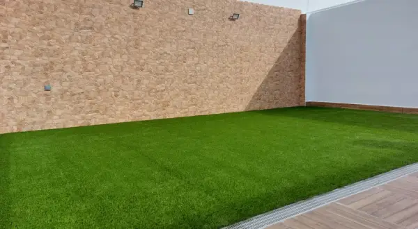 Césped artificial verde vibrante sobre una base impecable, ideal para crear tu oasis.