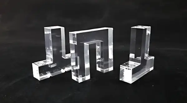 Tre forme geometriche trasparenti, realizzate in materiale acrilico, su sfondo nero.