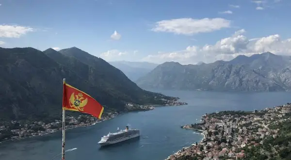 Montenegro backpacking: Fahne weht über Bucht mit Kreuzfahrtschiff und Bergen. Traumhafter Ausblick!