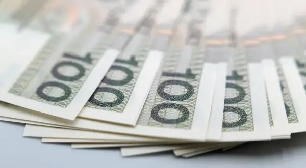 Stos banknotów 100 zł. Może symbolizować zasiłek stały dla osób z umiarkowanym stopniem niepełnosprawności.