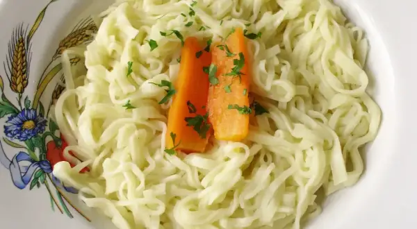 Prosta pasta fresca z marchewką i natką pietruszki, podana w ozdobnej misce.