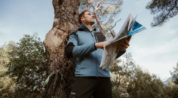 Un randonneur consulte une carte IGN pour s'orienter. C'est quoi une carte IGN ? C'est l'outil indispensable pour explorer la nature.