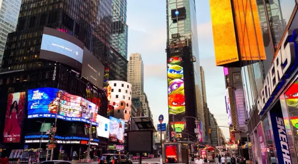 Manhattan, Nowy Jork, rozświetlony neonami i billboardami, z Żółwiami Ninja na jednym z budynków.