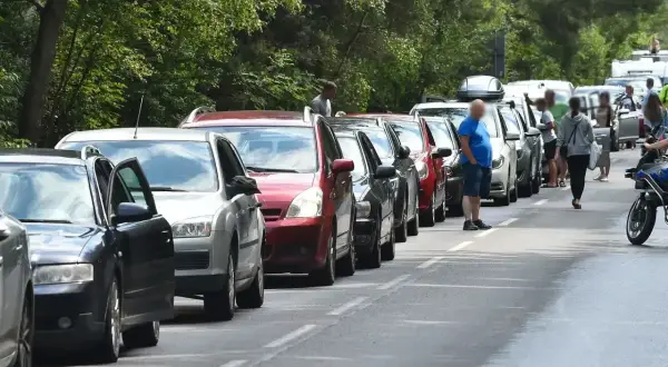 Długi korek samochodów na trasie do Helu. Kierowcy stoją w upale, czekając na przejazd.