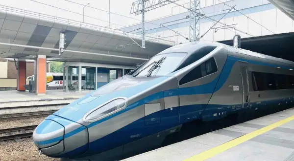 Moderner Zug mit blauen und silbernen Streifen steht am Bahnsteig. Vielleicht der Nachtzug nach Danzig?