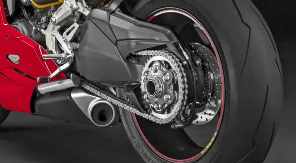 Detalle de la rueda trasera de una moto deportiva roja, mostrando el basculante monobrazo, cadena y neumático Pirelli Diablo Supercorsa.