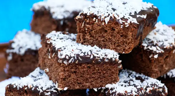 En hög med saftiga kärleksmums utan mjölk, toppade med chokladglasyr och kokosflingor.