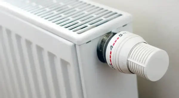 Biały grzejnik z termostatem. Gdy nie grzeje, sprawdź, jak naprawić grzejnik elektryczny, zaczynając od regulacji pokrętła.