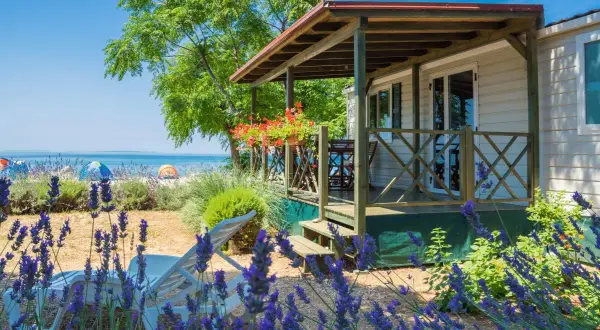 Idealne miejsce, gdzie na wakacje z dziećmi: domek przy plaży, leżaki i lawenda.
