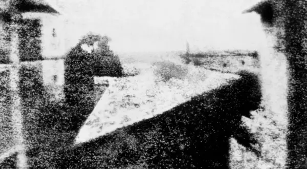 Pierwsze zdjęcie świata, kiedy wynaleziono fotografię. Widok z okna na ulicę, z sylwetką człowieka.