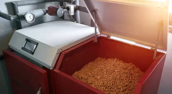 Pelletlager für Heizung: Die Frage, wie lange kann man Pellets lagern, ist wichtig. Hier sind sie in einem großen Behälter bereit für die Heizsaison.
