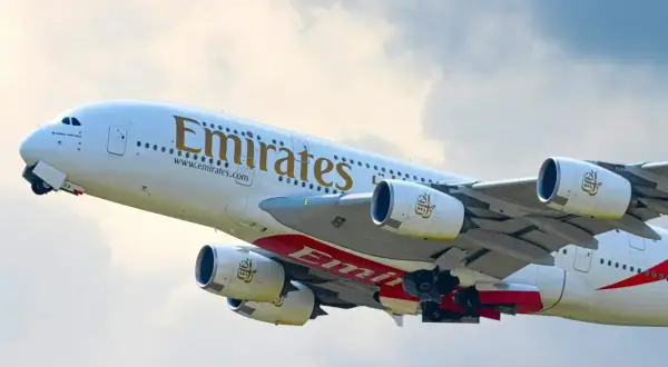 Samolot Emirates wznosi się w powietrze, gotowy do lotu. Zastanawiasz się, ile się leci do Dubaju?