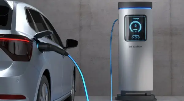 Samochód elektryczny podłączony do stacji ładowania. Sprawdź aktualne ceny ładowania samochodów elektrycznych, aby zaplanować podróż.