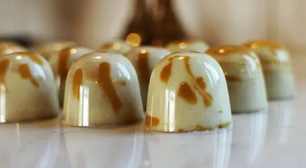 En rad blanka praliner med marmorerad ganache. Perfekt för ett ganache recept till praliner.