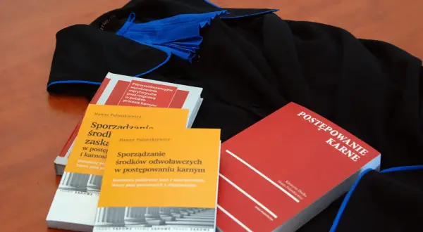 Książki prawnicze o postępowaniu karnym i sporządzaniu środków odwoławczych leżą obok tog. Czy rozprawa może się odbyć bez oskarżonego?