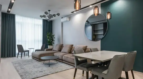 Nowoczesne rodzaje lamp sufitowych: wiszące nad stołem i wpuszczane w czarny pas.
