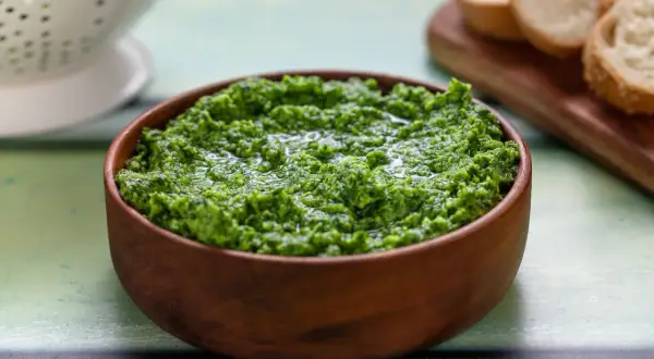 Pesto di rucola Bimby appena fatto, pronto per essere gustato con crostini di pane.