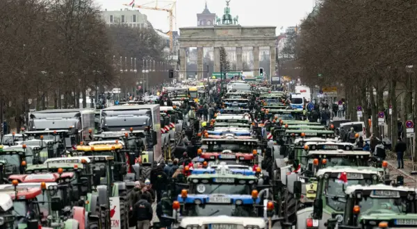 Traktoren blockieren die Straße vor dem Brandenburger Tor in Berlin. Ein **general streik** der Landwirte legt die Stadt lahm.