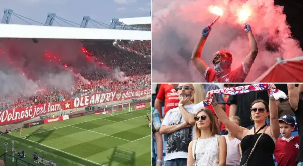 Kibice Wisły Kraków z racami i transparentem "Wolność jest tam, gdzie się nią żyje".