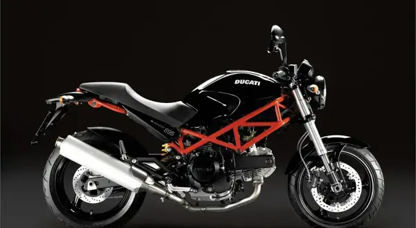 Ducati Monster 695 ficha técnica: una moto negra con chasis tubular rojo, asiento negro y escape plateado, lista para la carretera.