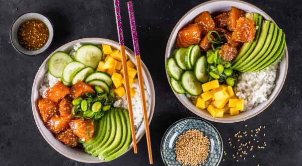 Zwei bunte Sushi Bowls mit Lachs, Avocado, Gurke, Mango und Edamame. Perfekte sushi bowl zutaten für einen gesunden Genuss.