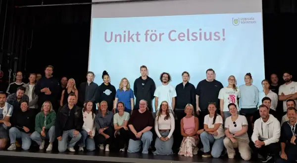 Gruppbild på personal och elever från Celsius skolan framför en projektorduk med texten "Unikt för Celsius!".