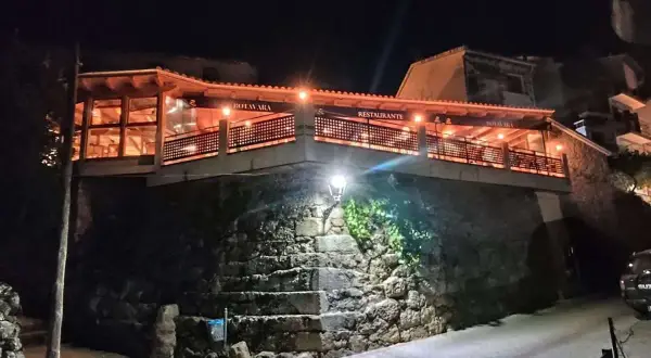 Restaurante Botavara San Jose, iluminado por la noche, con escaleras de piedra y una vista acogedora.