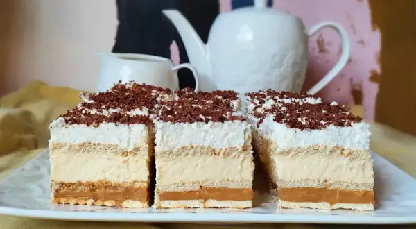 Pyszne ciasto bez pieczenia z warstwami kremu i polewą czekoladową. Idealne na deser.
