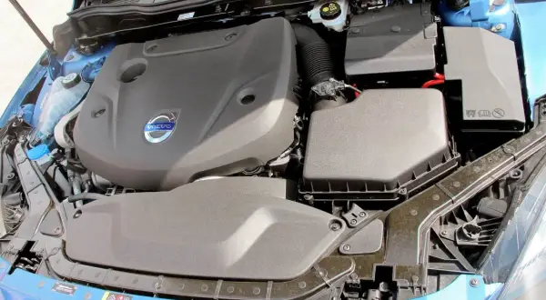 Motorutrymme på en blå Volvo V60. En kamremsbyte kan vara aktuell för att hålla motorn i toppskick.
