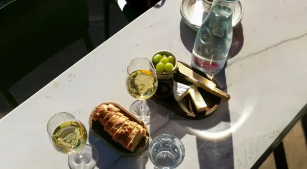 Dwa kieliszki białego wina, idealne do deski serów i pieczywa. Może to być orzeźwiające grenache wino.