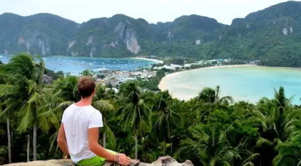 Mann genießt atemberaubenden Blick auf Bucht in Thailand. Tolle Thailand Urlaub Tipps für unvergessliche Momente.