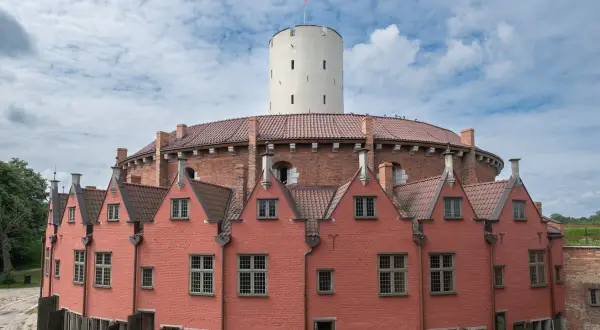 Gdańsk atrakcje dla młodzieży: Twierdza Wisłoujście z charakterystyczną wieżą i ceglanymi budynkami, idealne miejsce na odkrywanie historii.