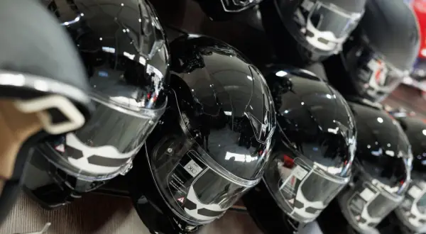 Błyszczące, czarne kaski motocyklowe na wystawie. Zastanawiasz się, jak dobrać kask motocyklowy? Wybierz idealny model dla siebie.