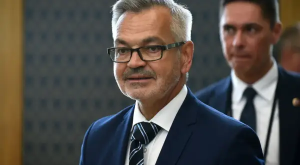Mężczyzna w okularach, w granatowym garniturze i krawacie, przypomina ambasadora Rosji.