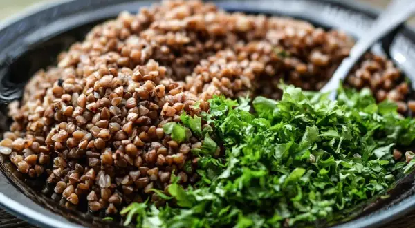 Un plat de sarrasin, un grain brun et nutritif, est garni d'herbes fraîches et vertes.