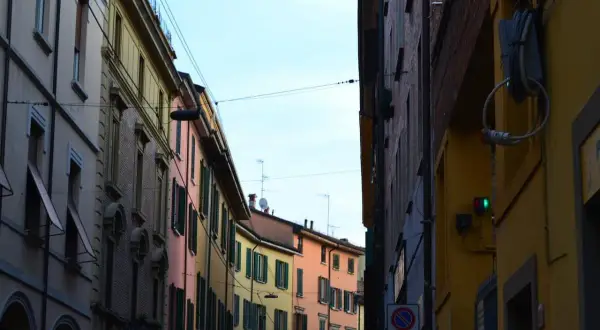 Edifici colorati di Bologna, con un semaforo verde che promette una vivace vita notturna.