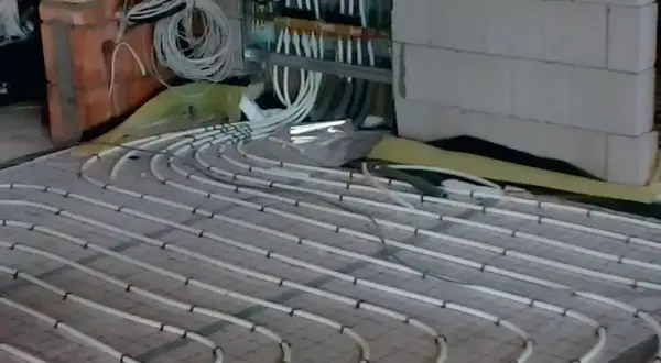 Instalacja ogrzewania podłogowego na 150m2. Czy pompa z kotła wystarczy? Widać rozdzielacz i rury.