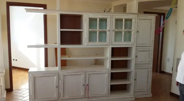 Mobile libreria decapato, con ante a vetro e vani a giorno. Il suo significato è un mobile con finitura effetto invecchiato.