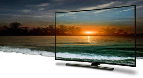 Zachód słońca na plaży z palmami, wyświetlany w jakości 4k full hd na zakrzywionym ekranie telewizora.