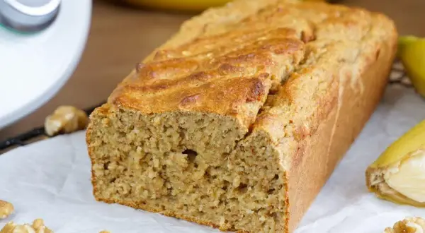 Saftiges Bananenbrot, frisch gebacken mit dem Thermomix. Nüsse und Bananen garnieren das köstliche Gebäck.