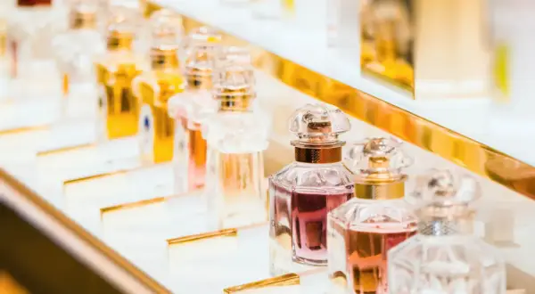 Eleganckie flakoniki z płynami w odcieniach różu i złota, kuszą obietnicą najpiękniejsze perfumy świata.