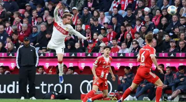 Fußballer in Aktion beim Pokalfinale Berlin. Ein Spieler in Weiß springt, während ein Spieler in Rot ihn beobachtet.