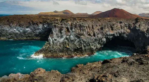 Acantilados volcánicos y mar turquesa en los Hervideros, Lanzarote. Un paisaje lunar con cuevas marinas.