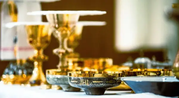 Złote kielichy i naczynia liturgiczne, gotowe na post eucharystyczny.