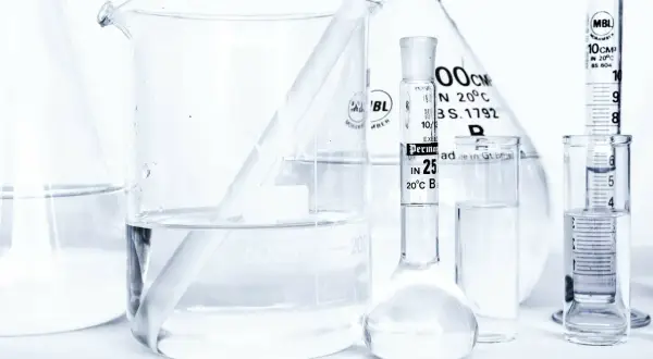 Laboratorium z kolbami i zlewkami, w których znajduje się płyn, być może butylene glycol, gotowy do analizy.