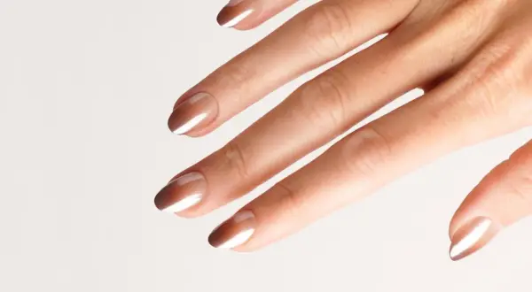 Eine Hand mit eleganten Nägeln im Ombre-Look, braun und weiß verlaufend.