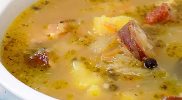 Gęsty, aromatyczny kapuśniak jak u babci, z kawałkami wędzonki, ziemniaków i marchewki, doprawiony ziołami i zielem angielskim.