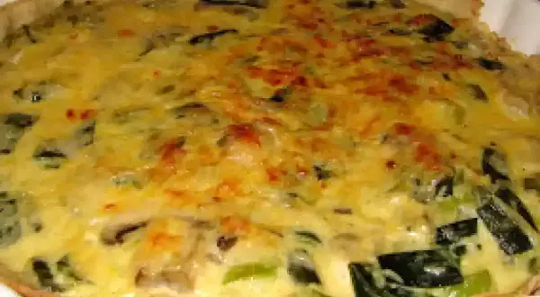 Tarta de puerros recién horneada, con su masa dorada y un relleno cremoso y sabroso.