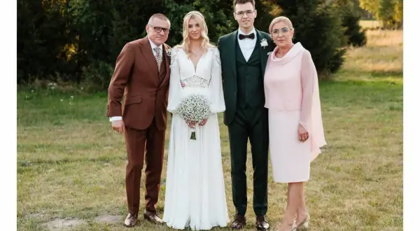 Rodzice i para młoda elegancko na ślub córki. Ojciec w brązowym garniturze, matka w różowej sukience.
