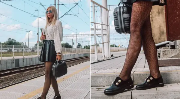 Stylowa kobieta na dworcu, w czarnych, ozdobnych mokasynach, które idealnie pasują do jej skórzanej spódniczki i rajstop w rybacką sieć.